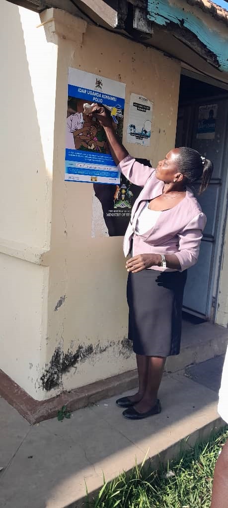 Edith Abeja, the District Health Educator displaying the polio campaign materials